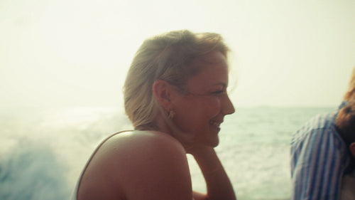 Beautiful woman with a radiant smile observes the ocean from a boat cruise