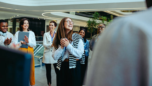 Friendly colleagues welcoming a new team member in a modern law firm environment