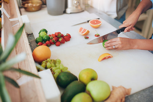 Woman cutting fruits at juice bar counter