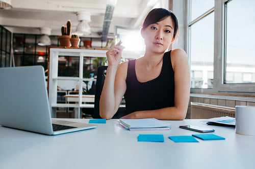 Confident young woman sitting at her desk