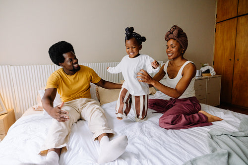 Happy family playing on bed