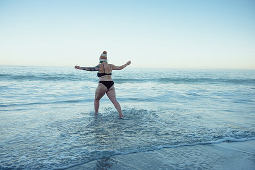 Woman enjoying the cold sea water at the beach