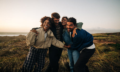 Friends embracing on a windy coastal trail