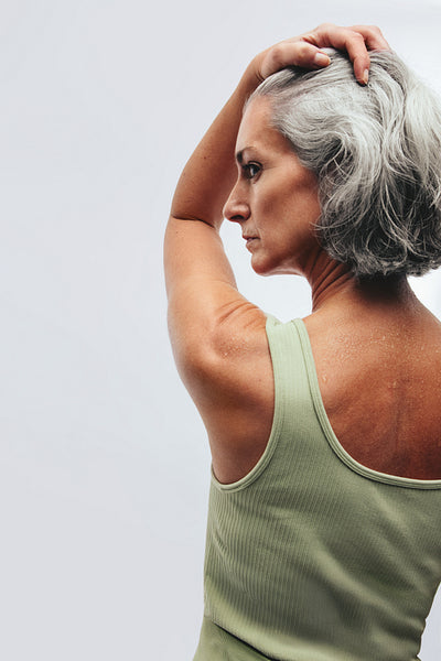 Woman holding hair back and stretching her arm