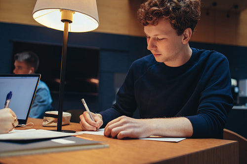 Young man studying in college library