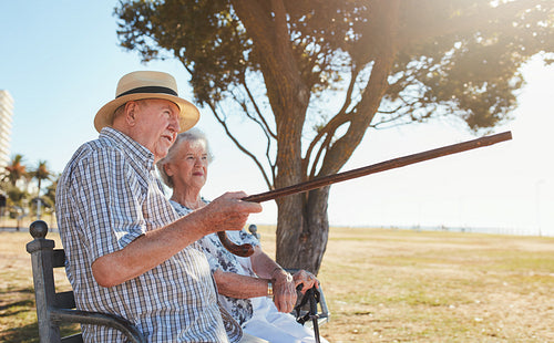 Senior couple relaxing on a park bench and enjoying the view