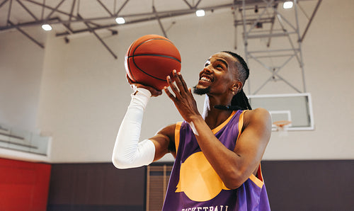 Basketball player focusing and aiming for a shot during practice in a gym