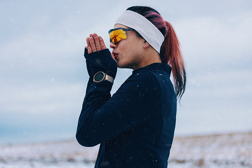 Cold air surrounds the woman in a winter portrait outdoors with sunglasses
