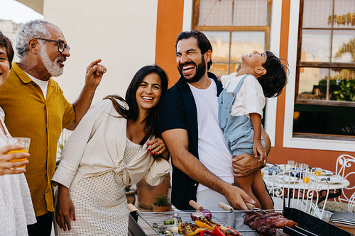 Happy family enjoying a Brazilian churrasco together outdoors