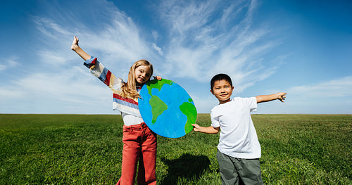 Kids hold globe outdoors for world awareness