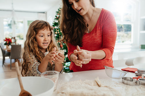 Mother and daughter preparing Christmas cookies.