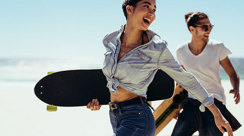 Young skaters walking by the beach