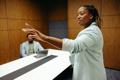 Confident African businesswoman leading a corporate presentation in boardroom