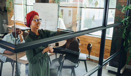 Team leader brainstorming with her team in a boardroom