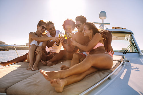 Young friends having drinks on the yacht deck
