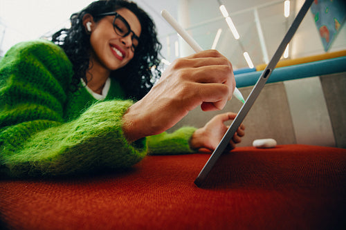 The woman explores digital drawing with a tablet and stylus in the library