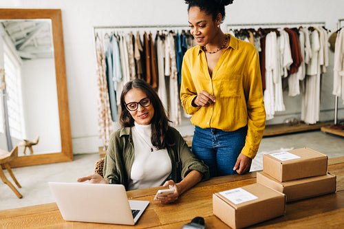 Business women using a laptop to review orders on their ecommerce website