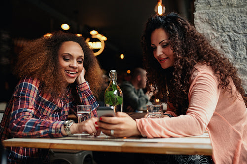 Young women sitting at a cafe using mobile phone