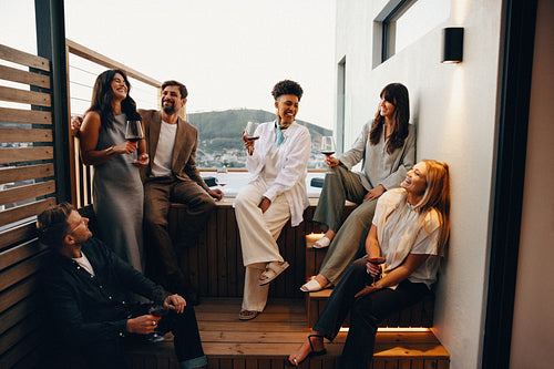 Friends enjoying drinks together on a cozy rooftop patio