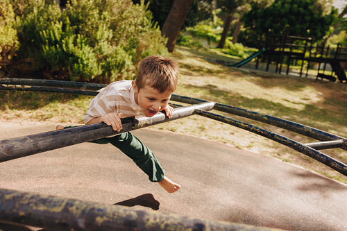 Child playing on jungle gym in a park on a sunny day