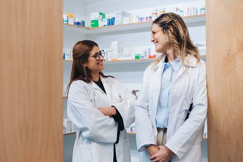 Two female pharmacists standing in a drug store