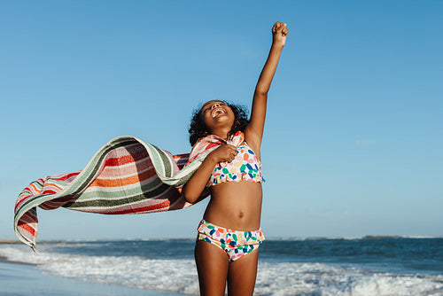 Excited young girl having fun at the beach during summer