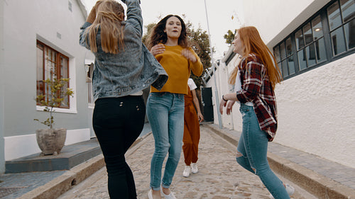 Female friends dancing outdoors