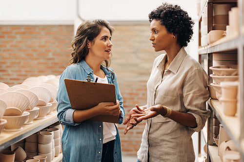 Creative businesswomen having a discussion in their ceramic store