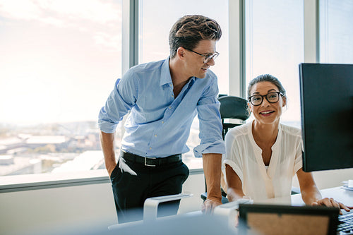 Happy business colleagues working together at their desk