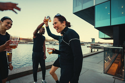 Their running group enjoys beer by the waterfront in the city
