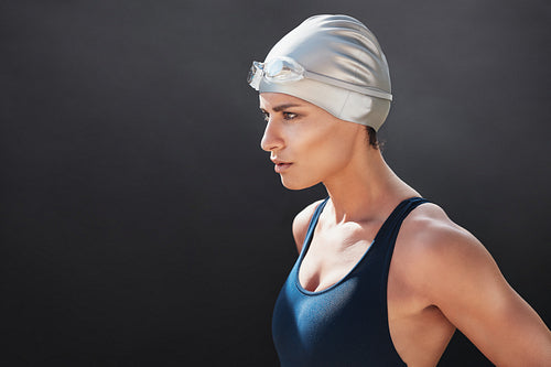 Fit young woman in swimming costume looking away