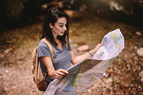 Female hiker in forest reading a map