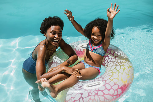 Mother and daughter enjoying summer holidays in pool