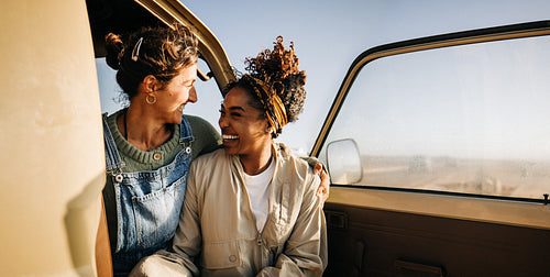 Shared moment: Friends smile together inside a camper van