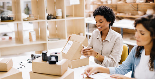 Cheerful online store owner preparing an order for shipping