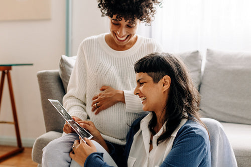 Excited lesbian couple looking at their ultrasound scan