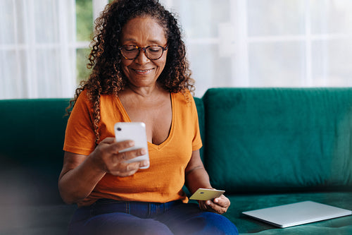 Senior woman using a smartphone for mobile banking at home