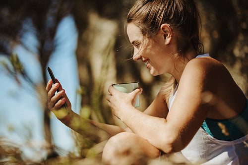 Taking a moment to check her phone while hiking