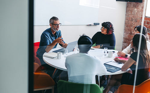 Experienced businessman briefing his colleagues in a meeting