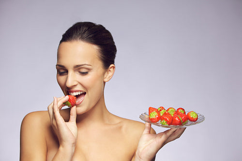 Gorgeous woman eating strawberry