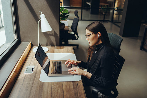 Focused businesswoman using a laptop in a coworking office