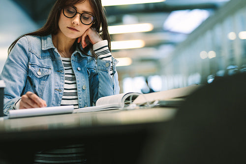 Girl writing notes at college campus