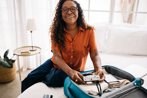 Retired tourist unpacking her travel essentials in a hotel room