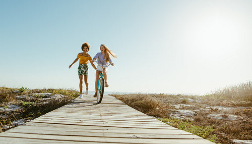 Friends with a bicycle on the seaside boardwalk