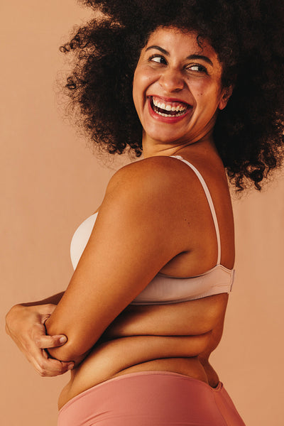 Plus size woman smiling happily while wearing underwear