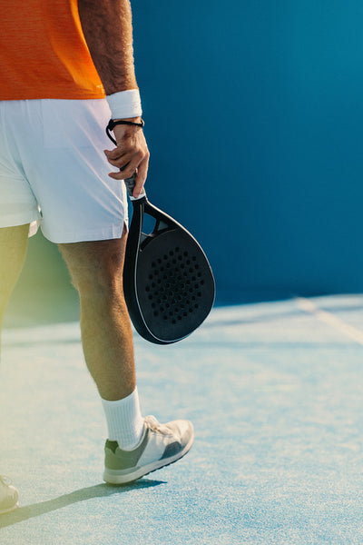 Man walking with his racket on a padel court