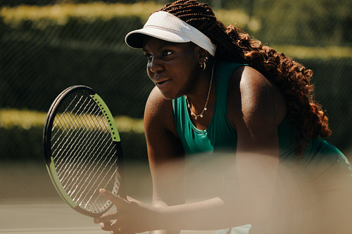 Focused African-American woman playing tennis outdoors