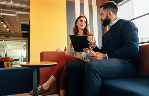 Two young entrepreneurs having an important discussion in a lobb