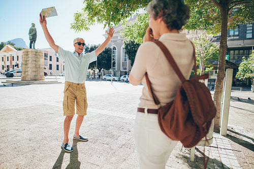Woman taking photos of an excited senior man