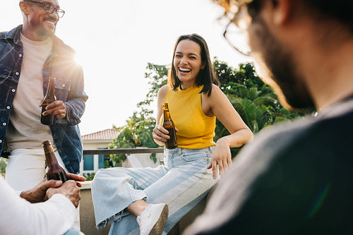 Diverse group of friends enjoying sunny day with drinks on a rooftop